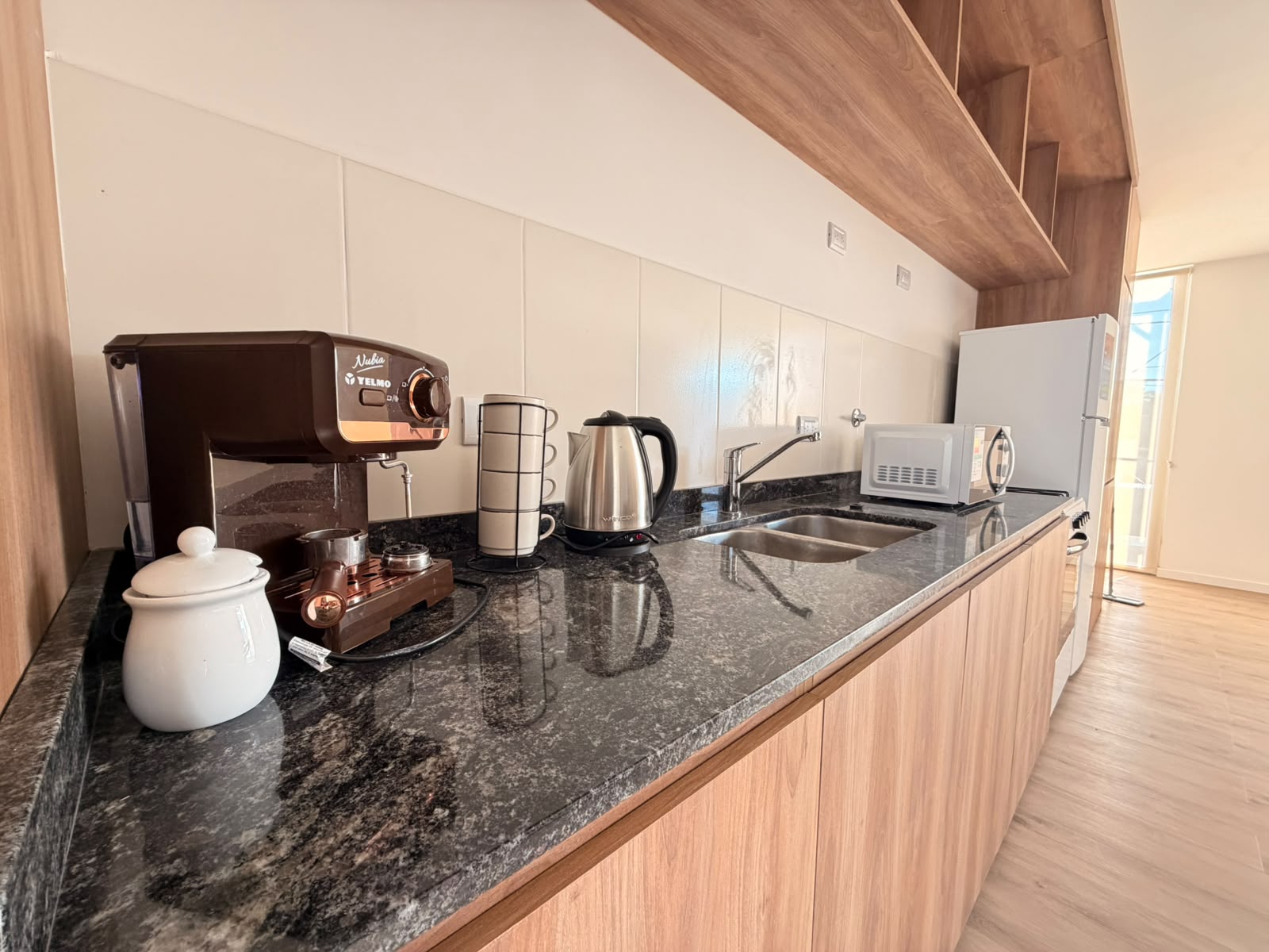 Cocina con cafetera, pava eléctrica, microondas y heladera